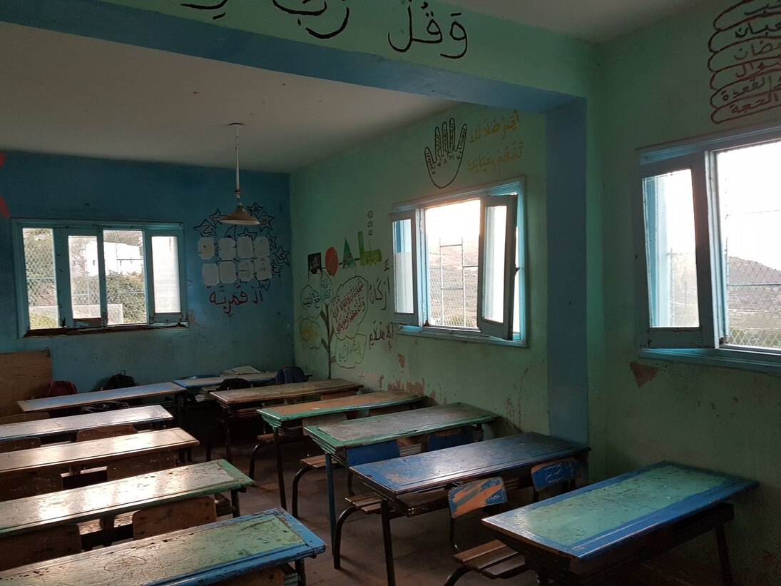 Ein Klassenraum mit Tischen und Stühlen in einer Marokkanischen Schule