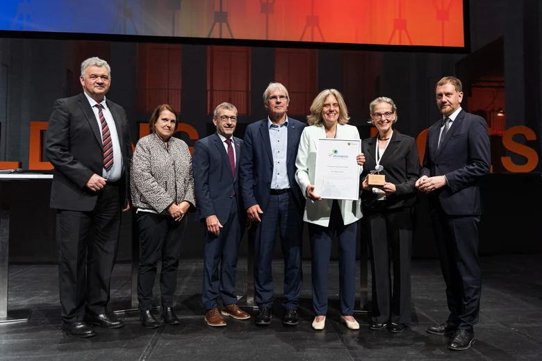 MP und Preisträgerin Dr. Schmid gemeinsam mit fünf weiteren Personen auf der Bühne der Wissenschaftskonferenz
