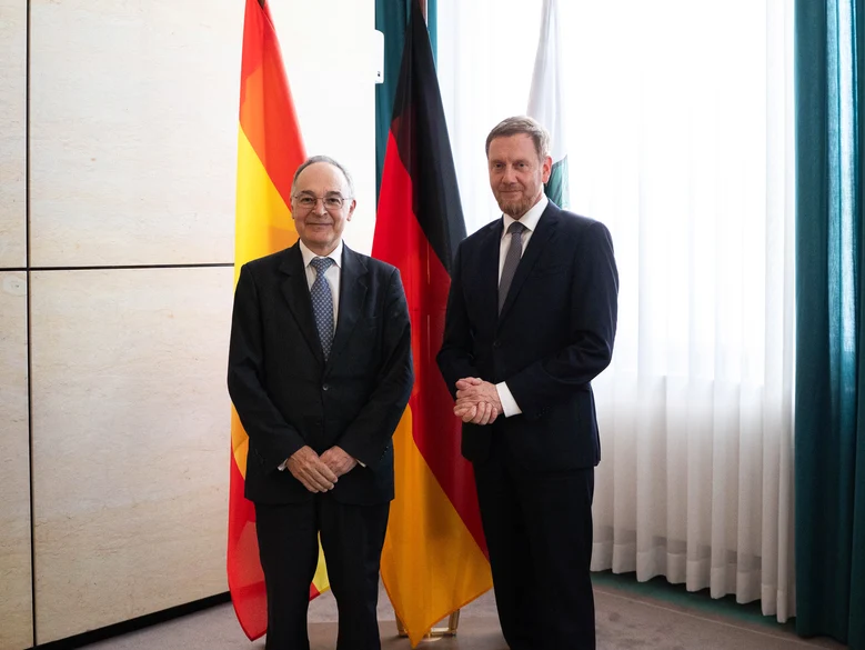 MP und der Botschafter von Spanien vor drei Fahnen