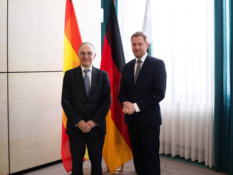 MP und der Botschafter von Spanien vor drei Fahnen