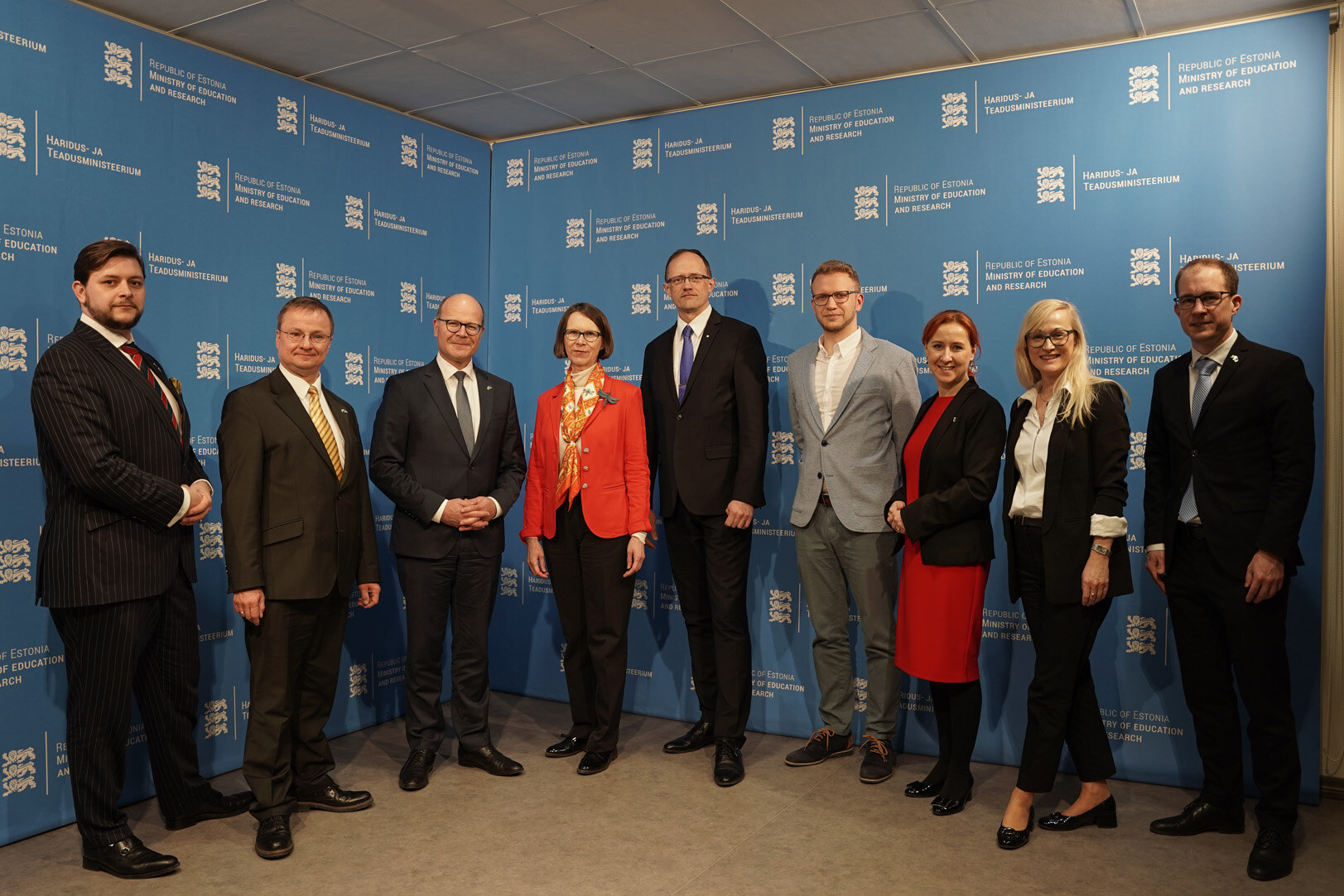 Eine Gruppe Menschen steht vor einer Wand des estnischen Bildungsministeriums.